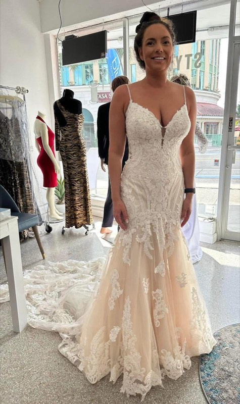 Bride in a fitted lace gown by the atelier window